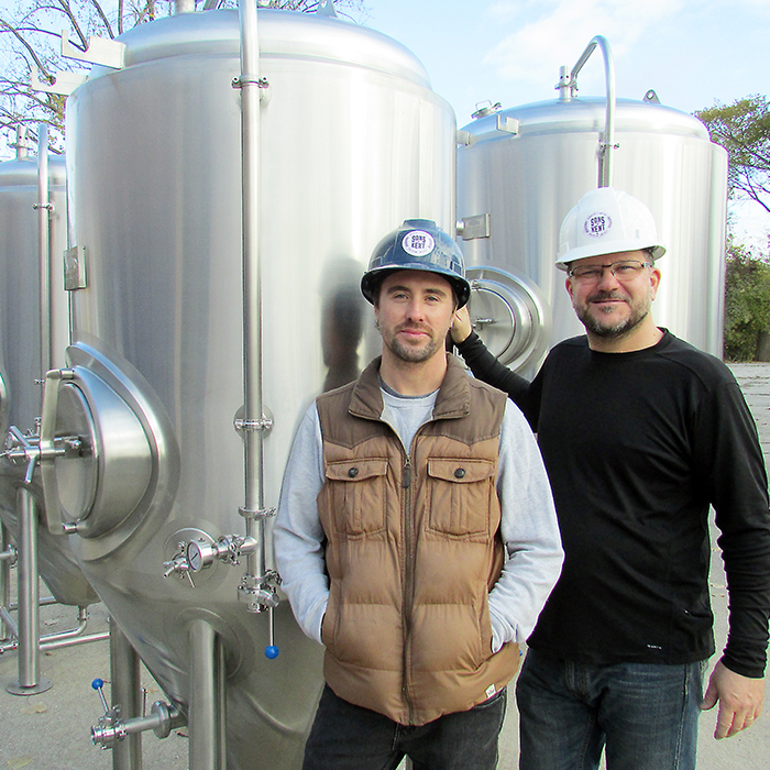 Colin Chrysler, left, and Doug Hunter show off some of their brewing vats that arrived Friday at their Sons of Kent Craft Brewery on King Street East in Chatham.