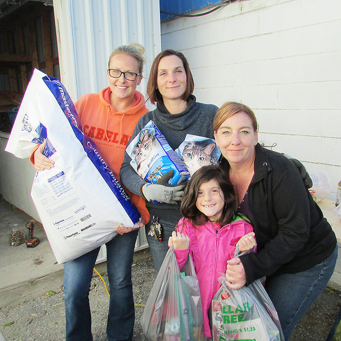 From left, Nicole Van Hintum, Myriam Armstrong, Sofia Male, and Paula Ready showcase some of the donations that poured into Pet and Wildlife Rescue after a theft last week that saw someone steal all their pet food and other necessities to operate the animal shelter in Chatham.