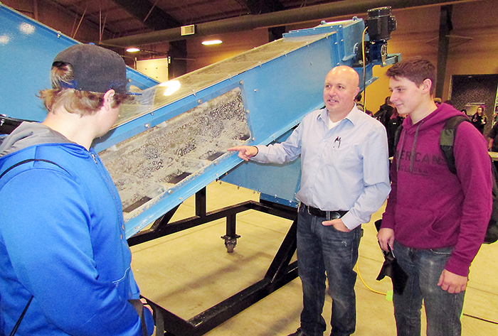 BDM Millwright’s Jim Waters discusses how the company’s display model dry bulk handler conveyor operates with students Robert Boccanfuso, left, and Luke Duffield at the Experience the Trades Expo that took place Nov. 16 and 17 at the John D. Bradley Centre.