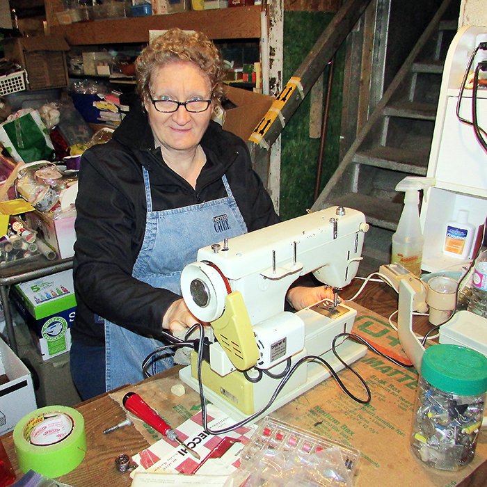 Canadian Food For Children volunteer Mary Giesbrecht repairs a sewing machine that will be shipped overseas to help those in need. Giesbrecht fixes about 200 machines a year.