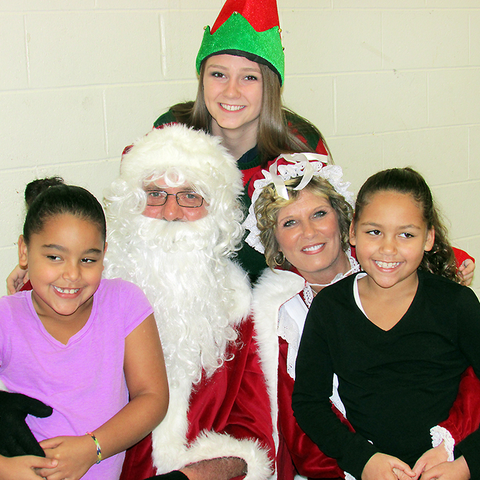 Ieesha Collier, left, and her sister Kaylin Collier, visited with Santa and Mrs. Claus at the East Side Pride Breakfast with Santa at the W.I.S.H. Centre on Saturday morning and were excited with the treat bag Santa brought for them.