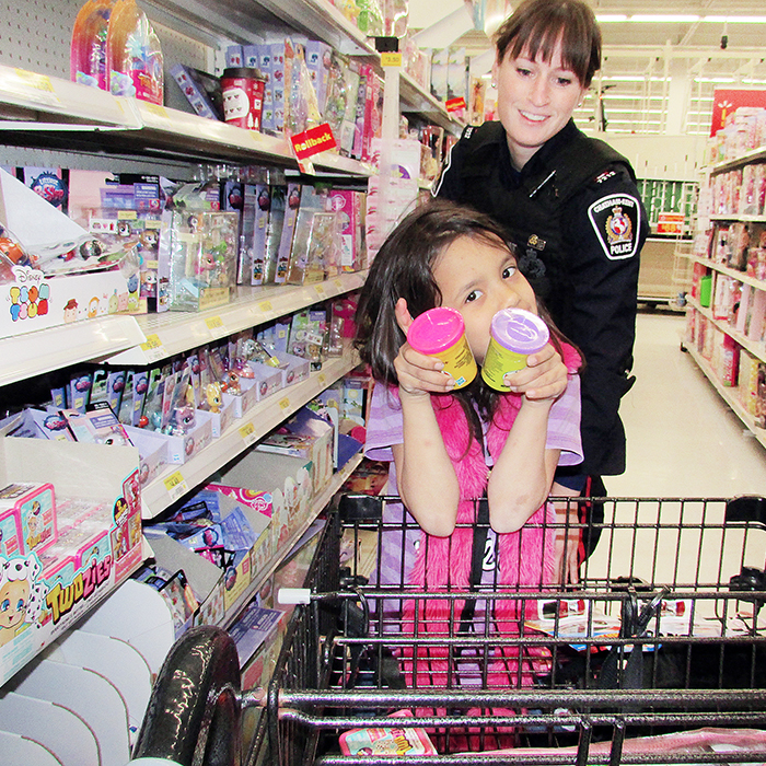 Catina Beaucage, 7, shows off some of the items she picked up during the annual Shop With A Cop event Saturday morning at Wal-Mart. With her is Const. Jennifer Jacobson of the Chatham-Kent Police Service.