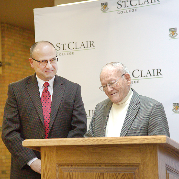 Frank Uniac, right, and family friend Mike Peach, left, share a reflective moment at the unveiling of the plaque naming the newly renovated auditorium at St. Clair College in honour of Uniac’s father-in-law, Alva Clapp, a man who left a legacy of giving and caring for his community. (Mark Benoit image)