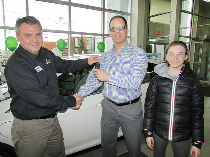 Dustin O’Neil of Essex and his daughter, Evelyn are the first customers to buy an electric car, the Ford Focus electric, from Victory Ford salesperson Mark Jackson, shown handing over the keys recently. Victory Ford is fully certified to sell and service electric cars and has the only accessible charging station in Chatham available to the public.