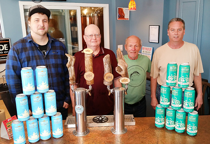 From Left, Wesley Thompson, Mike Grant, Ken Royal and Mike Dumouchelle showcase some of the canned Bayside Brewing Co. products. The Erieau-based craft brewery is expanding operations, having recently received municipal council approval on the rezoning of a property on Charing Cross Road where Bayside will can their own product, and perhaps expand brewing operations in the future.