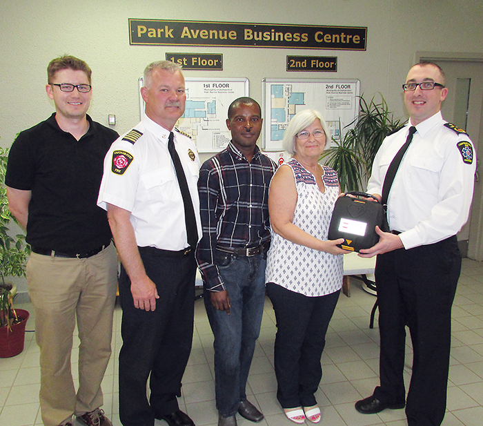 Chatham-Kent emergency services personnel recently donated a defibrillator to staff at the Park Avenue Business Centre. From left, Ian Clark, Fire and Emergency Services Chief Ken Stuebing, Albert Rwamihigo, Penny Croteau and Donald MacLellan of Medavie Emergency Services.