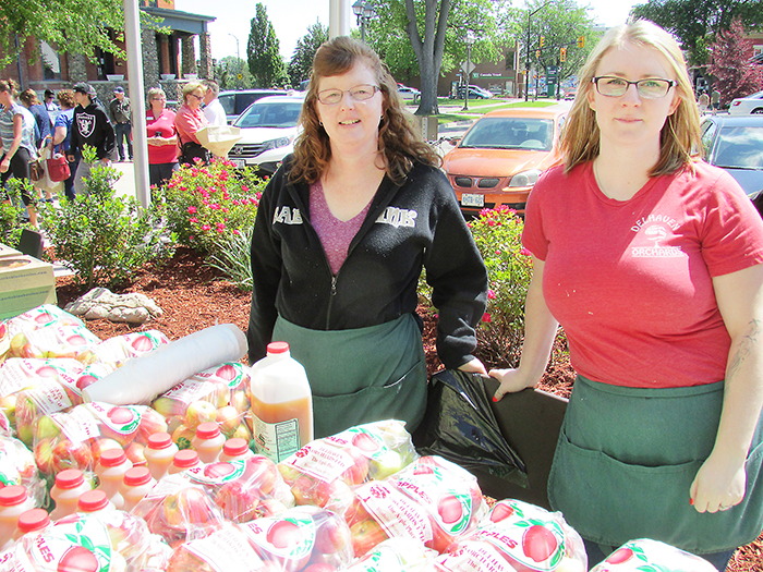 Kim Watt, left and Kristen Gardiner of Del Haven Orchard on Talbot Trail, just west of Blenheim, were busy selling locally grown apples and locally produced cold apple cider at their booth at the kick off to Local Food Week at the Civic Centre in Chatham on Monday.