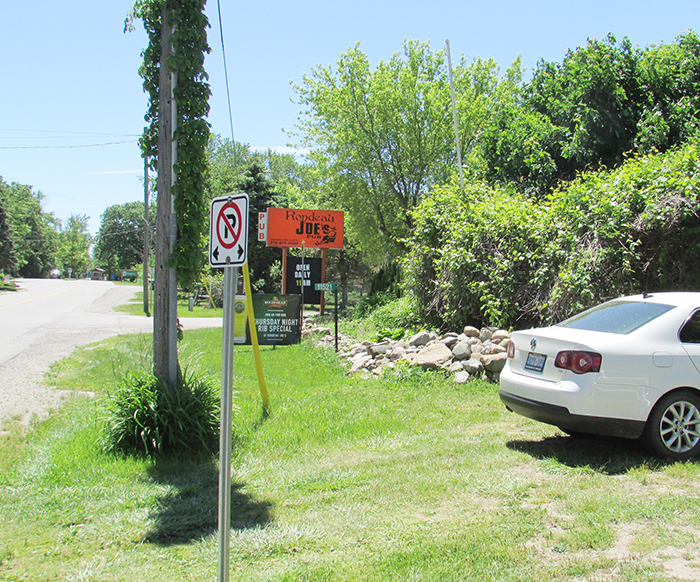 Staff from Rondeau Joe’s park well off the boulevard on Wildwood Line, behind no parking signs that are meant to prevent people from parking on the boulevard. Paul Trudell, owner of the restaurant, said the signs obstruct his staff from fully accessing parking on his property.
