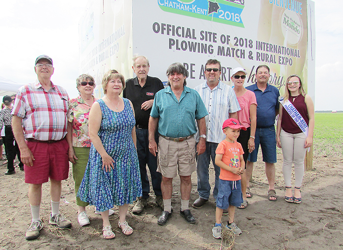 Host landowners on Pain Court Line for the 2018 International Plowing Match set for September of 2018 gathered at the unveiling of the sign marking the IPM site recently. Pictured from left are Clayton and Mary Ellen Crow, Lucille and Jean Marie Laprise, Gerard Faubert, Scott and Terry Pritchard with son Keegan, John Faubert, and Princess of the Furrow Brynn Depencier.