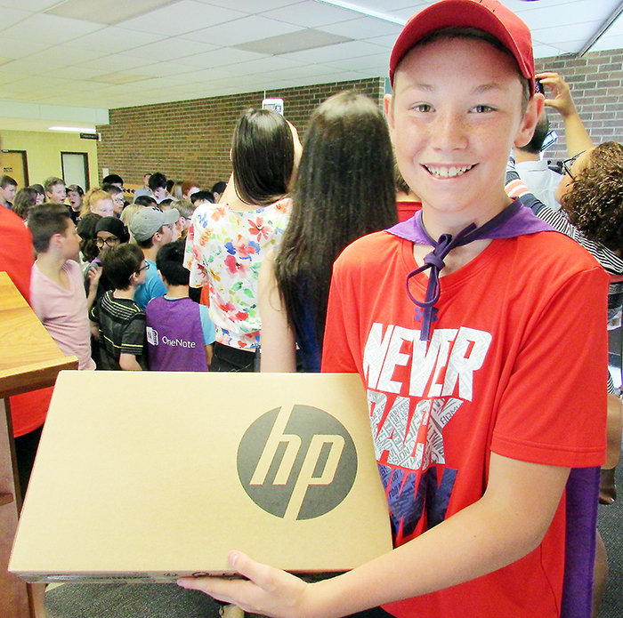 Indian Creek Public School student Braden St. Pierre, who was part of the winning Microsoft project, showcases one of the 28 HP Pro-G3 laptops that are a part of the winning prize pack given to the school.