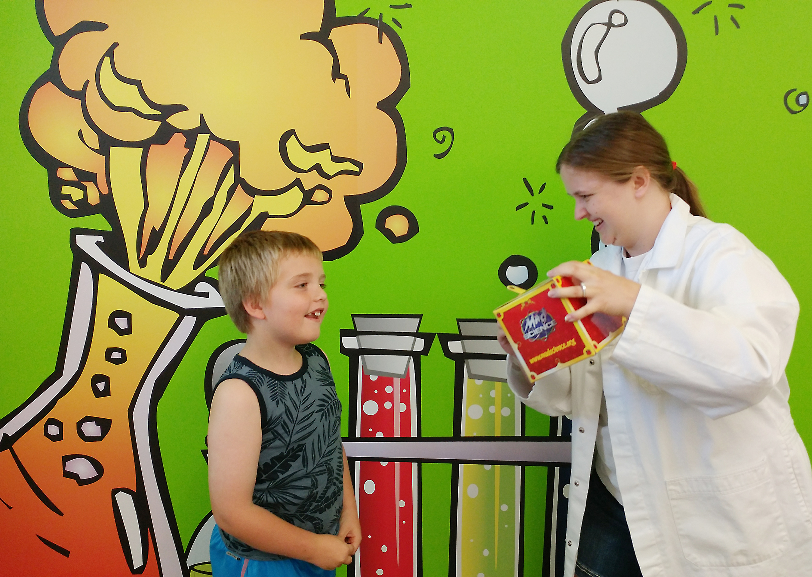 “Mad” scientist Krypton Kat Vido, right, showcases a Curious Cube from the Sources of Forces program for children, a take-home project that supports the science that is taught.