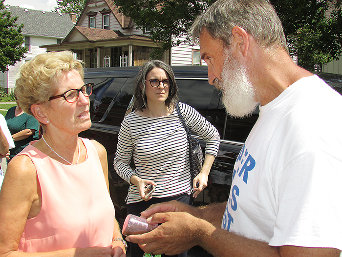 Ontario Premier Kathleen Wynne discusses sediment concerns in wells with Water Wells First representatives during a stop in Chatham on July 27.