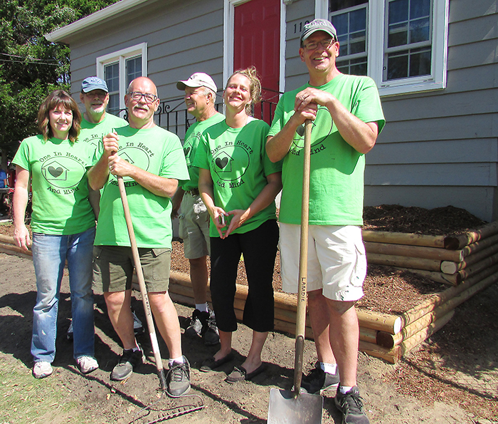 From left, Jodi Maroney, Dwight Byrd, Jay Jamieson, Mark Labadie, Jennifer Allossery and Mike Maroney celebrate two days of hard work in front of Allossery’s home in Chatham. An army of volunteers spent two days repainting the house and sprucing up her yard as part of a Backyard Mission Project.