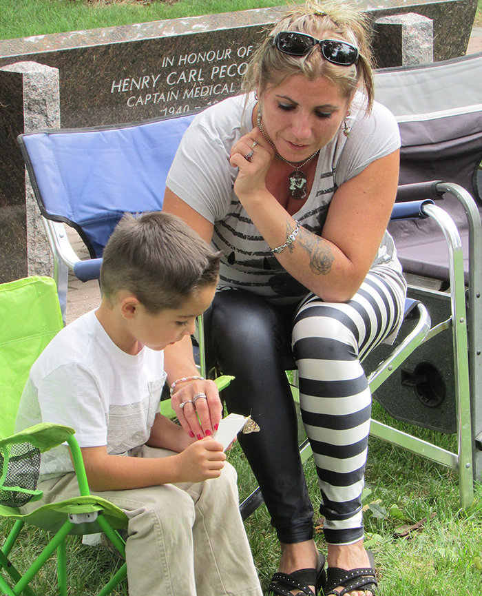 Travis Houle, 4, releases a butterfly Sunday in memory of his Nanna and Pappa, while his mother, Tashia, watches. They were part of the 10th annual VON Butterfly Release Sunday in Veterans’ Gardens in Chatham.